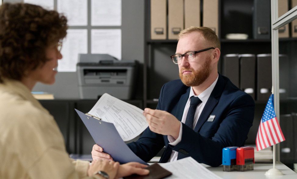 Bearded male government employee holding application form while talking to woman